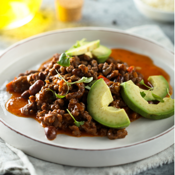 A plate of ground beef taco meat with avocado slices on the side, possibly seasoned with the ingredients listed such as ancho chile powder, cumin, paprika, and oregano.